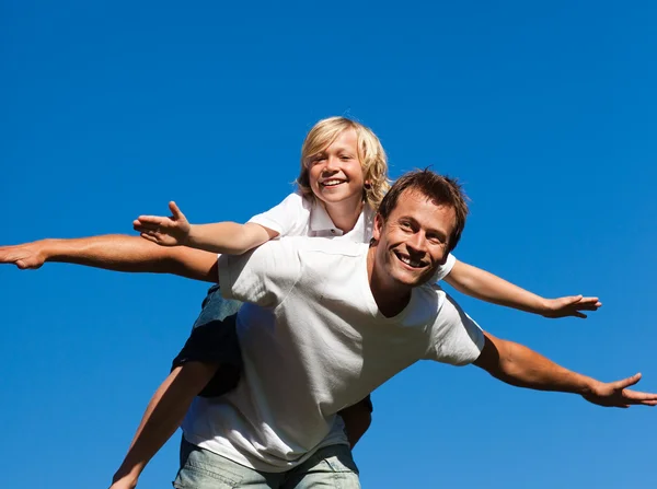Ung man ger ung pojke piggyback ride — Stockfoto