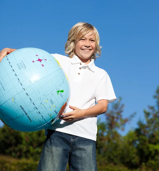 Lindo chico jugando con un globo terrestre — Foto de Stock