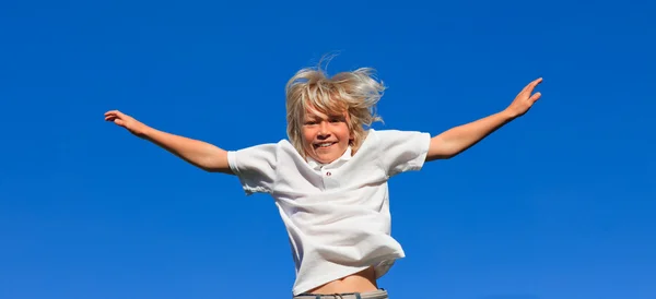 Счастливый ребенок, прыгающий в воздухе — стоковое фото