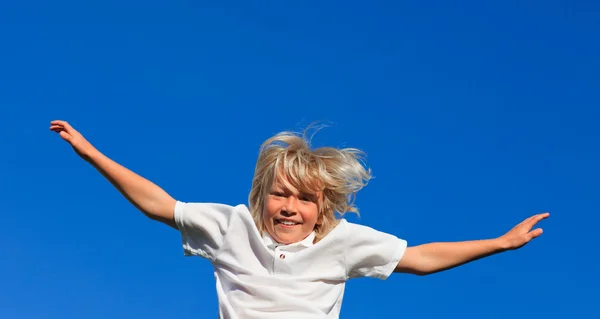Rapaz feliz saltando no ar — Fotografia de Stock