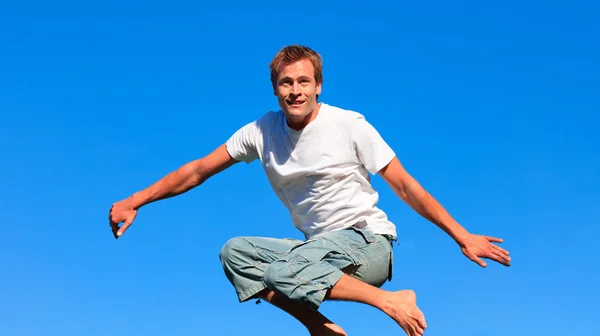 Молодой человек прыгает в воздух — стоковое фото