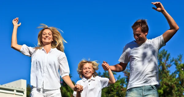 Happy family jumping in the air — Stock Photo, Image