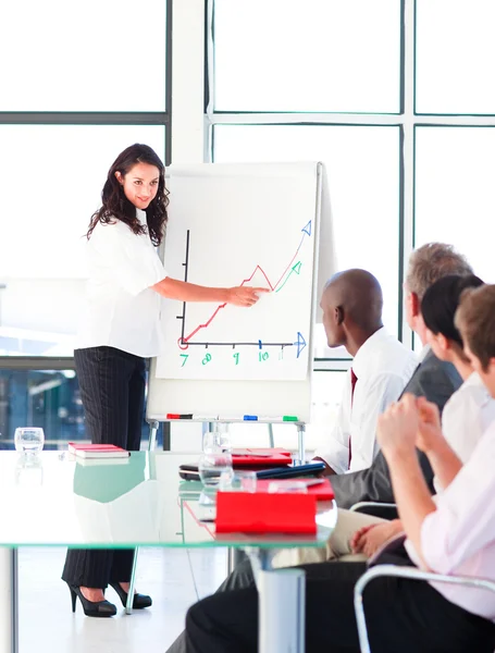 Businesswoman explaining a graph to her team — Stock Photo, Image