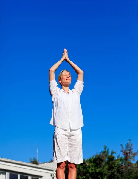 Jovem mulher praticando ioga — Fotografia de Stock