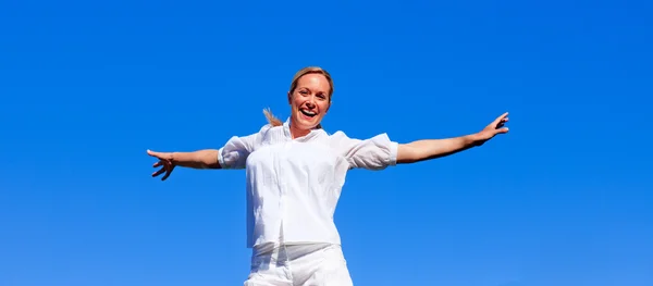 Щаслива жінка стрибає на відкритому повітрі — стокове фото