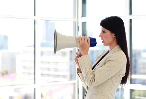 Молодая деловая женщина кричит через мегафон — стоковое фото