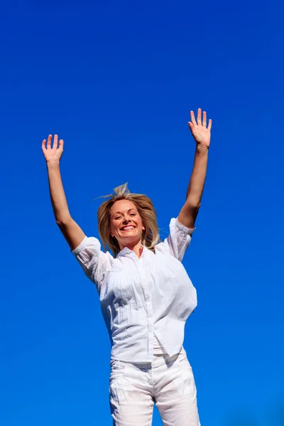 Mujer despreocupada disfrutando de la vida contra el cielo azul — Foto de Stock