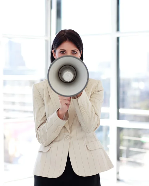 Businesswoman shouting through megaphone to the camera — Stock Photo, Image