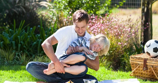 Far och son njuta av en picknick — Stockfoto