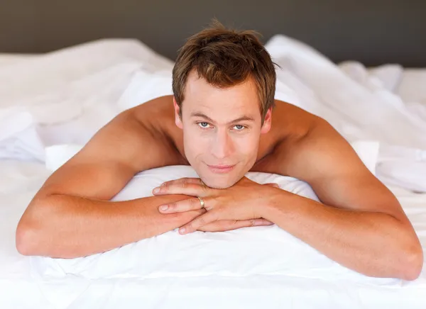 Yakışıklı erkek yatakta kameraya bakarak yalan — Stok fotoğraf