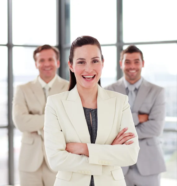Sorridente donna d'affari con il suo team sullo sfondo — Foto Stock