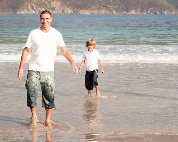 Vader en zoon spelen op een strand — Stockfoto