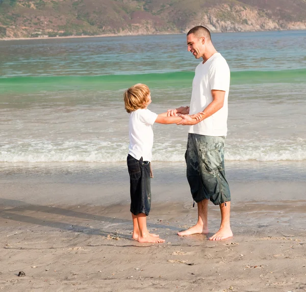 Vader en zoon spelen op een strand — Stockfoto