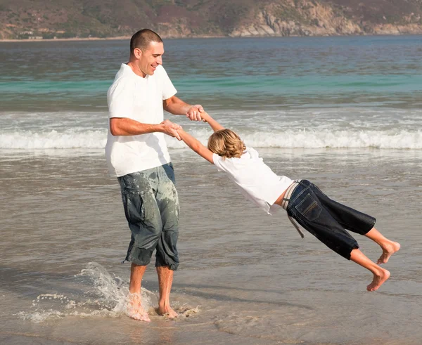 Padre e figlio che giocano su una spiaggia — Foto Stock