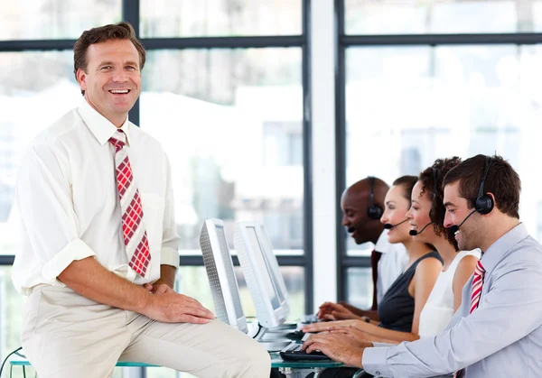 Lachende volwassen manager in een callcenter — Stockfoto