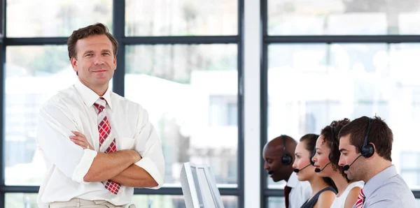 Effectieve leider met gevouwen armen in een callcenter — Stockfoto