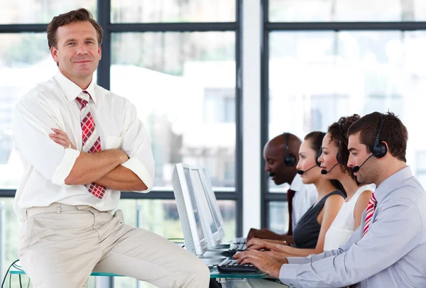 Senior manager with crossed arms in a call center — Zdjęcie stockowe