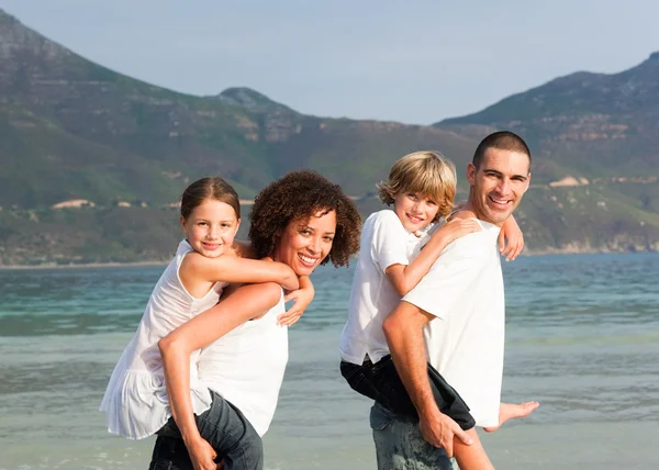 Família feliz jogando na praia — Fotografia de Stock
