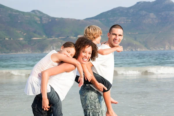 Ευτυχισμένη οικογένεια παίζει στην παραλία — Φωτογραφία Αρχείου
