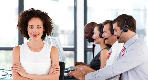 Atractiva empresaria con los brazos cruzados en un call center — Foto de Stock