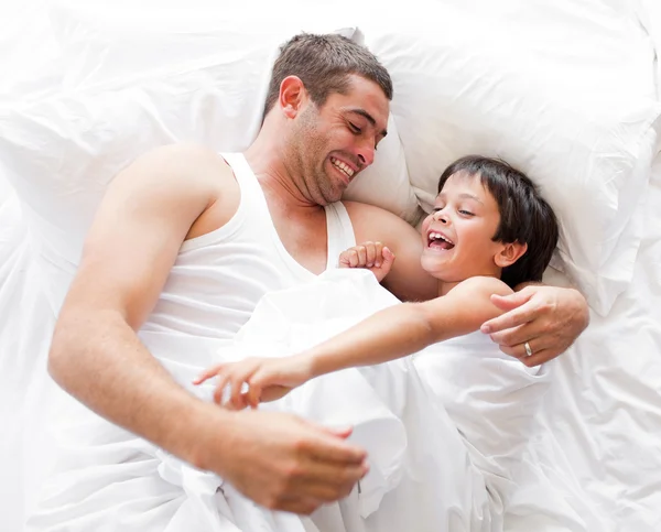 Ojciec i syn, leżąc na łóżku i spanie — Zdjęcie stockowe