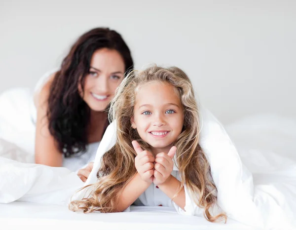 Charming mother and daugther embracing on bed — Stock Photo, Image