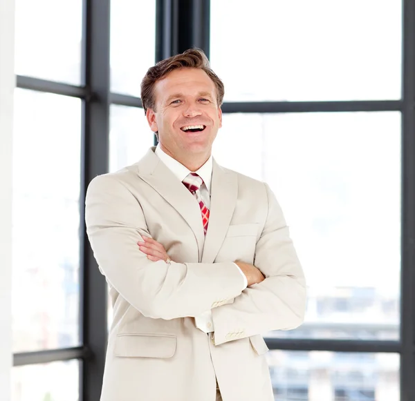 Бізнес-лідер зі складеними руками посміхається в камеру — стокове фото
