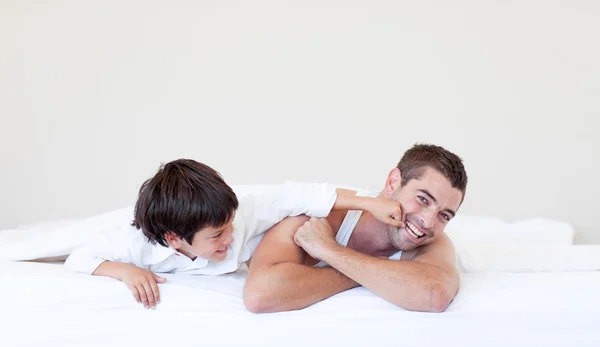 Feliz pai e filho se divertindo na cama — Fotografia de Stock