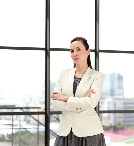 Серйозна бізнес-леді, що стоїть в офісі — стокове фото