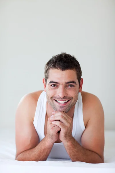 Aantrekkelijke man liggend in bed glimlachen — Stockfoto