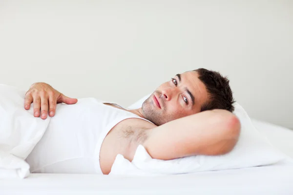 Knappe man in bed liggen — Stockfoto