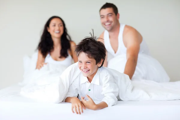 Familie spielt mit Sohn im Bett — Stockfoto