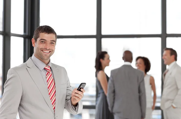Jonge zakenman op telefoon op kantoor met zijn team — Stockfoto