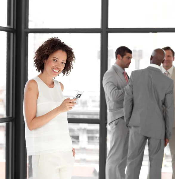 Smiling businesswoman on phone in office with her team — Stock Photo, Image