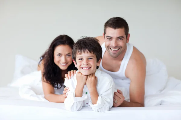 Happy family on bed with thumbs up — Stock Photo, Image