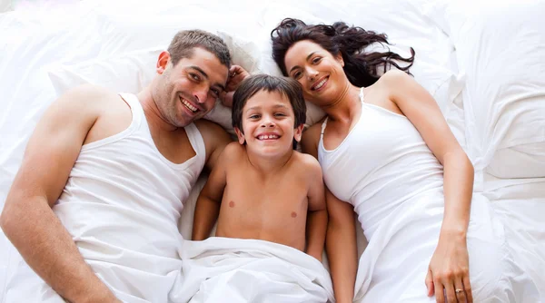 Familia jugando acostado su hijo en la cama —  Fotos de Stock