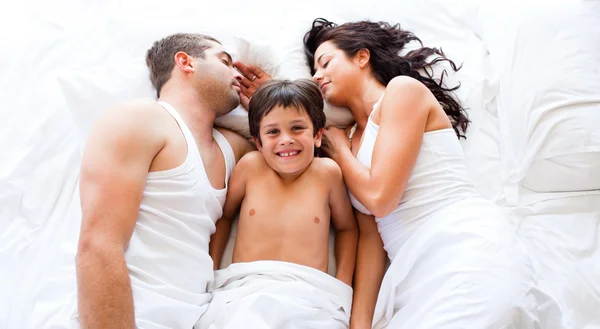 Усміхнений син з батьками спить — стокове фото