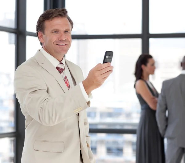 Портрет улыбающегося бизнесмена по телефону со своей командой — стоковое фото