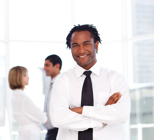 African businessman with folded arms smiling at the camera — Stock Photo, Image