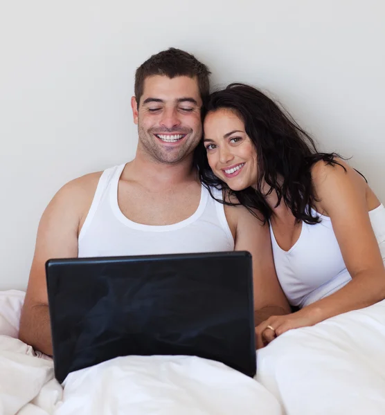 明亮夫妇在一张床上使用笔记本电脑 — 图库照片