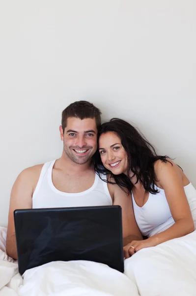明亮夫妇在一张床上使用笔记本电脑 — 图库照片