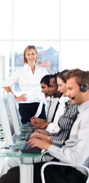 Líder feminina concentrada com uma equipe em um call center — Fotografia de Stock