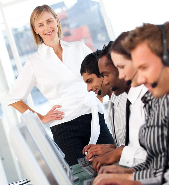 Koncentrovaná ženské vůdce s týmem na call centrum — Stock fotografie