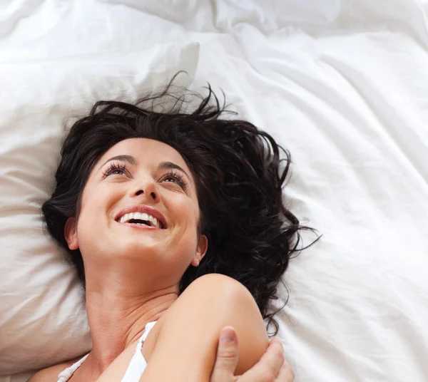 Schöne Frau auf einem Bett liegend — Stockfoto