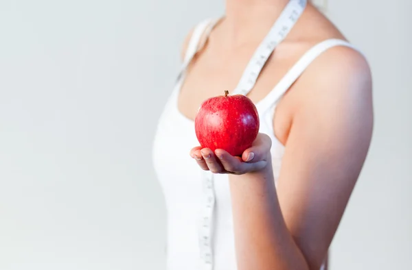 Close-up of a woman holding an apple with focus on apple — Stock Photo, Image