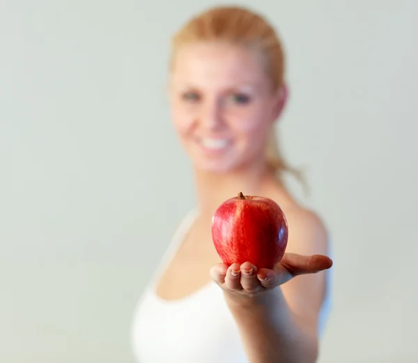 Young woman holding an apple with focus on apple — Stock Photo, Image