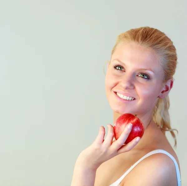 Friendly woman holding an apple with focus on woman — Stock Photo, Image