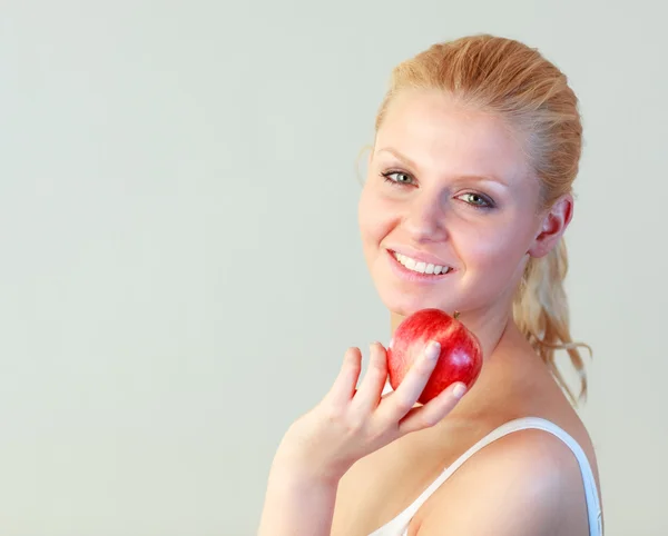 Close-up of a young woman holding an apple with focus on woman — Stock Photo, Image