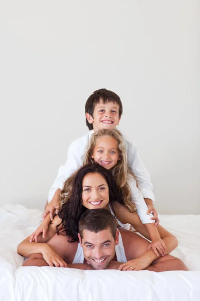 그들의 침대에 누워 행복 한 가족 — 스톡 사진