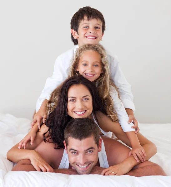 Счастливая семья лежит на кровати — стоковое фото